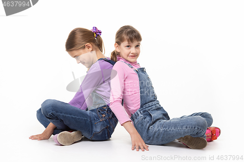 Image of Sisters quarreling pushing each other\'s backs