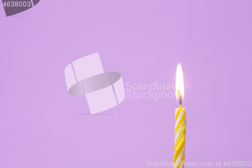 Image of One festive candle is lit, light purple background