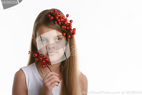 Image of Portrait of a girl with a bunch of berries in her hair, as well as with a bunch in her hand