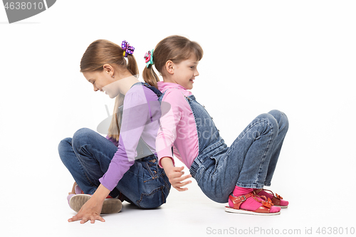 Image of Children sitting on the floor have fun pushing their backs, isolated on white background