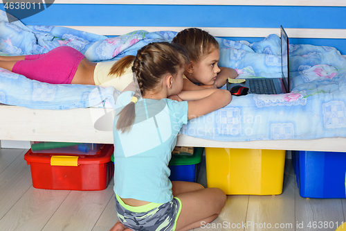 Image of Children watch cartoons on a laptop screen.