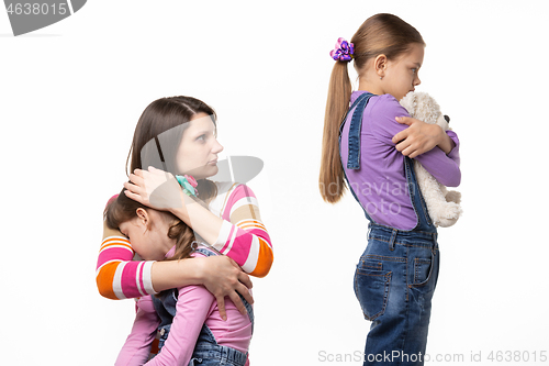 Image of Mom scolds the eldest daughter who took the toy from the youngest