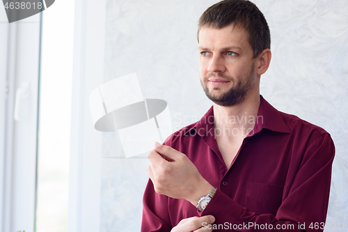 Image of young man in the morning dresses shirt while going to office work