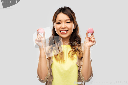 Image of happy asian woman with macarons