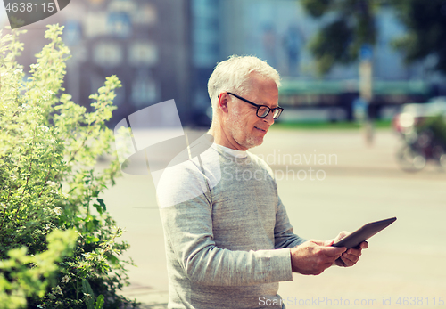 Image of senior man with tablet pc on city street