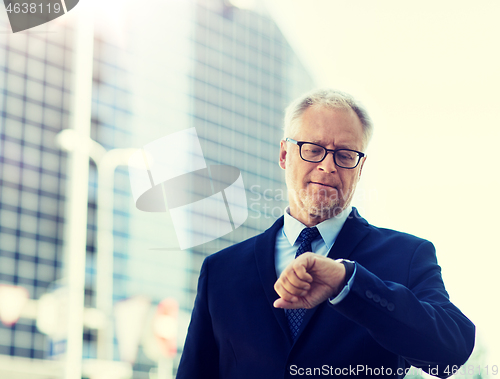 Image of senior businessman checking time on his wristwatch