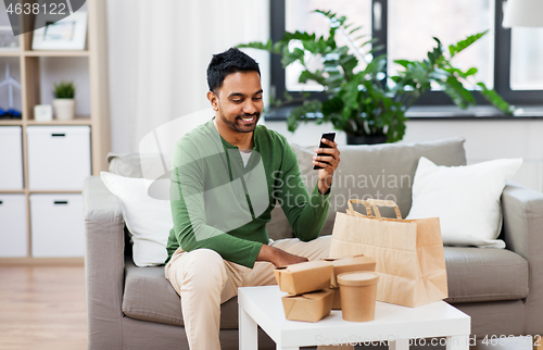 Image of indian man using smartphone for food delivery