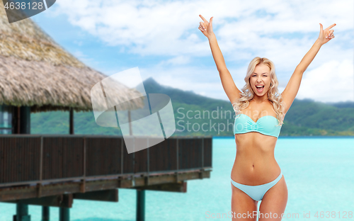 Image of happy young woman in bikini doing fist pump