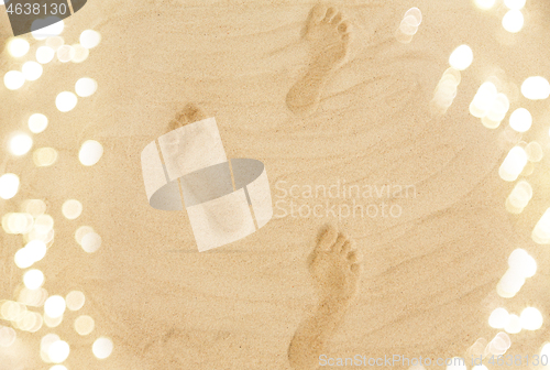 Image of footprints in sand on summer beach