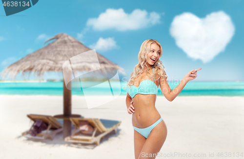 Image of happy smiling young woman in bikini on beach