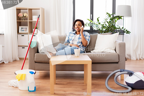 Image of woman calling on smartphone after home cleaning