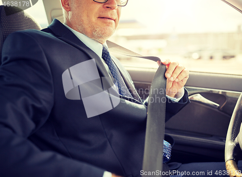 Image of senior businessman fastening car seat belt