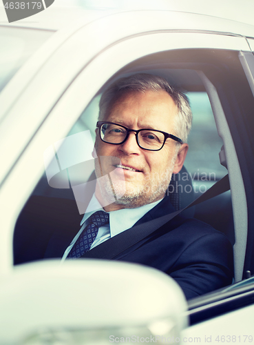 Image of happy senior businessman driving car