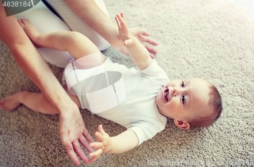 Image of happy mother playing with baby at home