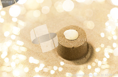 Image of sand shape made by mold with shell on summer beach