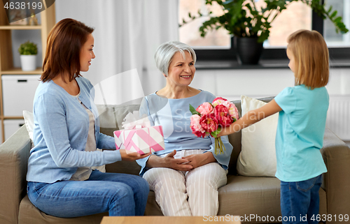 Image of granddaughter giving flowers to grandmother