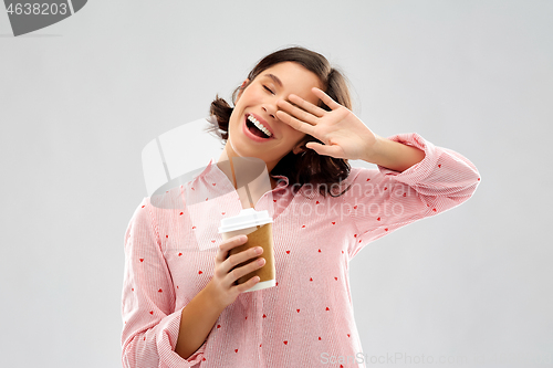 Image of happy young woman in pajama with cup of coffee