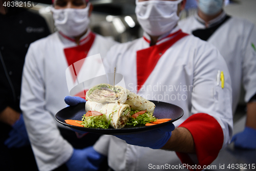 Image of group chefs standing together in the kitchen at restaurant weari