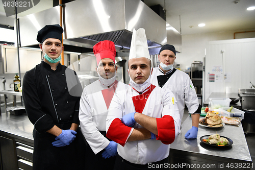 Image of group chefs standing together in the kitchen at restaurant weari