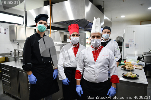 Image of group chefs standing together in the kitchen at restaurant weari