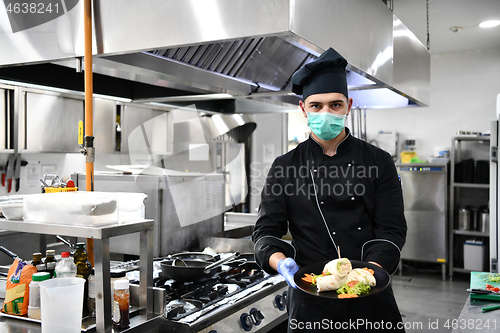 Image of chef cook wearing face protective medical mask for protection fr