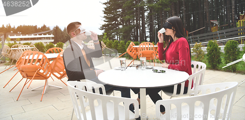 Image of couple with protective medical mask  having coffee break in a re