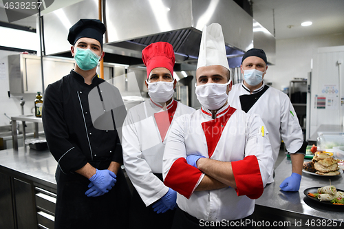 Image of group chefs standing together in the kitchen at restaurant weari