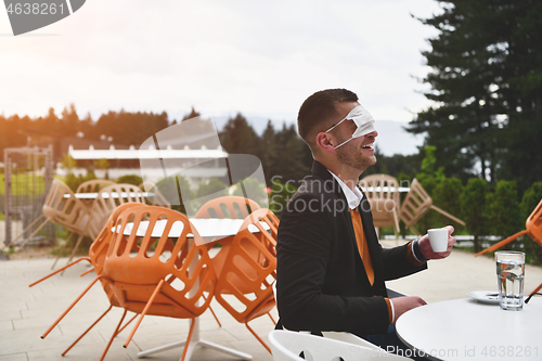 Image of funny man in restaurant drinking coffee wearing face mask