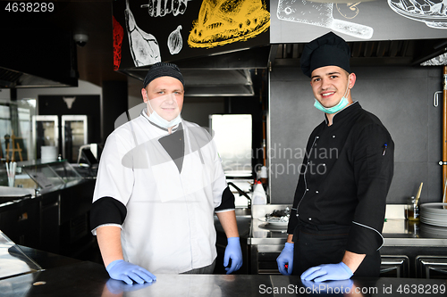 Image of group chefs standing together in the kitchen at restaurant weari