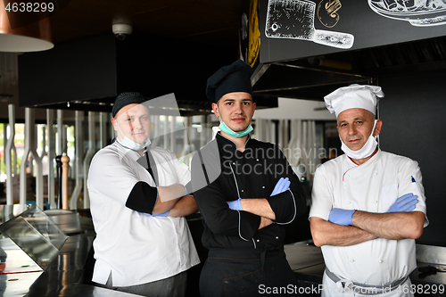 Image of group chefs standing together in the kitchen at restaurant weari