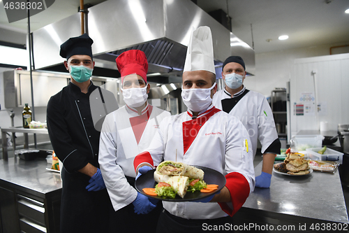 Image of group chefs standing together in the kitchen at restaurant weari