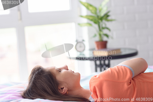 Image of Girl sleeps in bed against the background of a window, close-up