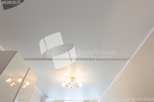 Image of Classic white matte stretch ceiling with five lamp chandelier in the center