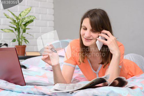 Image of Happy unemployed girl found an ad in the newspaper and calls up by phone with the employer