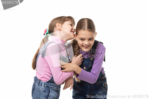 Image of Girl bites her sisters ear having fun