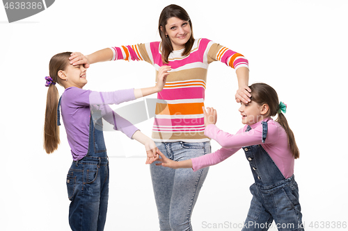 Image of A woman cannot calm two fighting girls