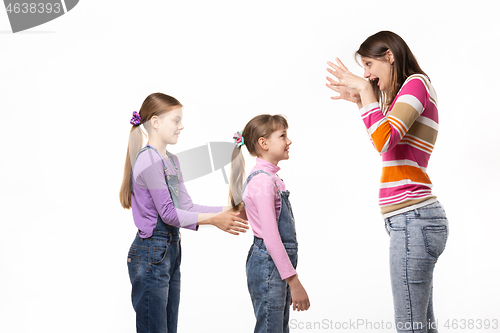 Image of Mom scares her two daughters, isolated on white background