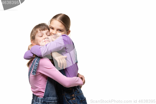 Image of Two girlfriends happily hug each other, white background