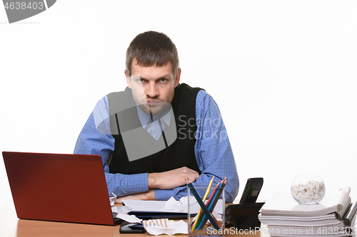 Image of frownman sits at an office table on a white background