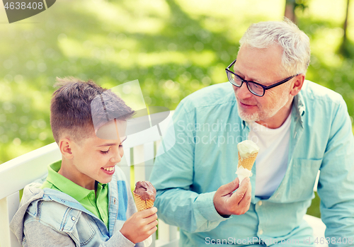 Image of old man and boy eating ice cream at summer park