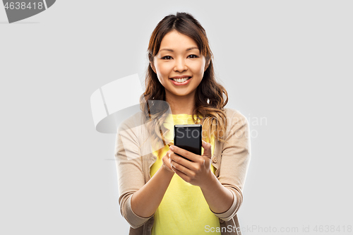 Image of happy asian woman using smartphone