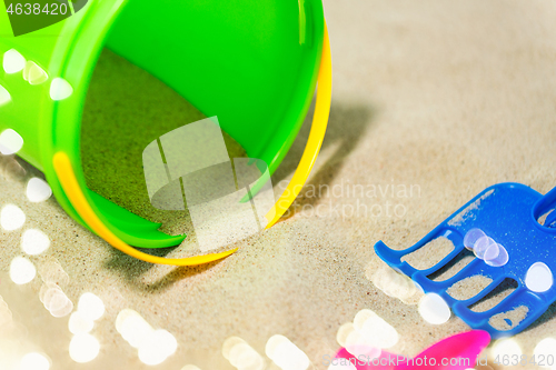 Image of close up of bucket and rake on beach sand