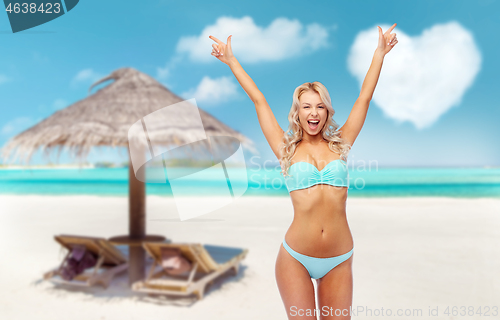 Image of happy young woman in bikini doing fist pump