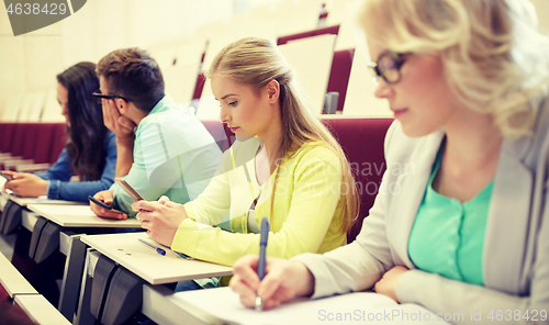 Image of student girl with smartphone at lecture