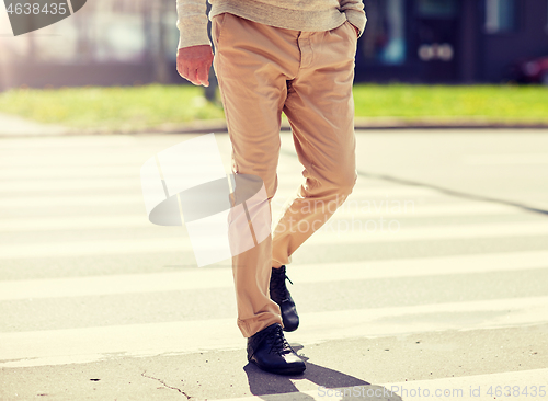 Image of senior man walking along city crosswalk