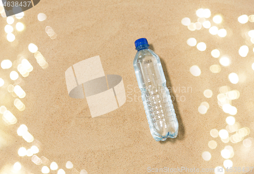 Image of bottle of water on beach sand