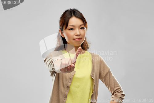 Image of young asian woman threatening with finger