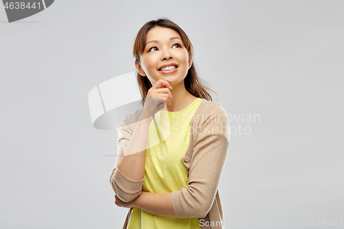 Image of happy asian woman over grey background