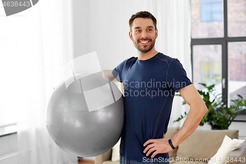 Image of man exercising with fitness ball at home