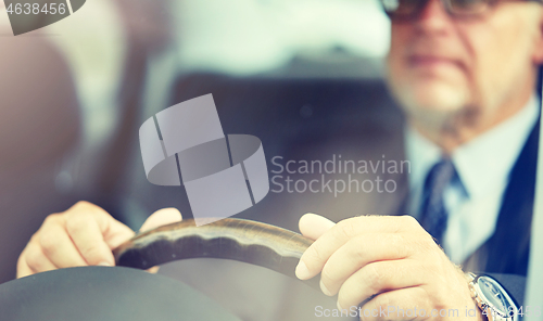 Image of senior businessman hands driving car